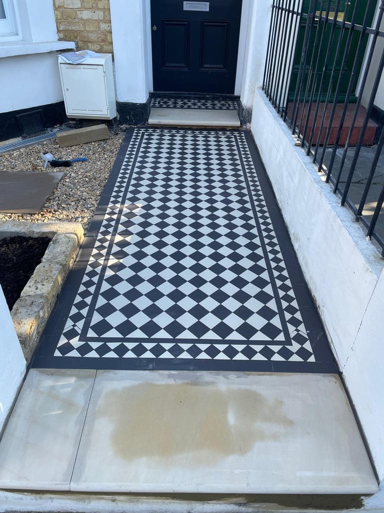 Victorian tiled entrance hallway with black and white checkered tile pattern and decorative border